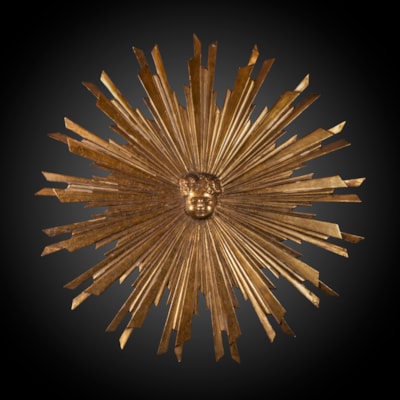 Soleil en bois finement sculpté et doré, au centre une tête d'enfant entourée de rayons, Italie, XIXème (diamètre 80 cm)